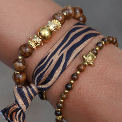Armband mit goldener Kugel und braunem Stein