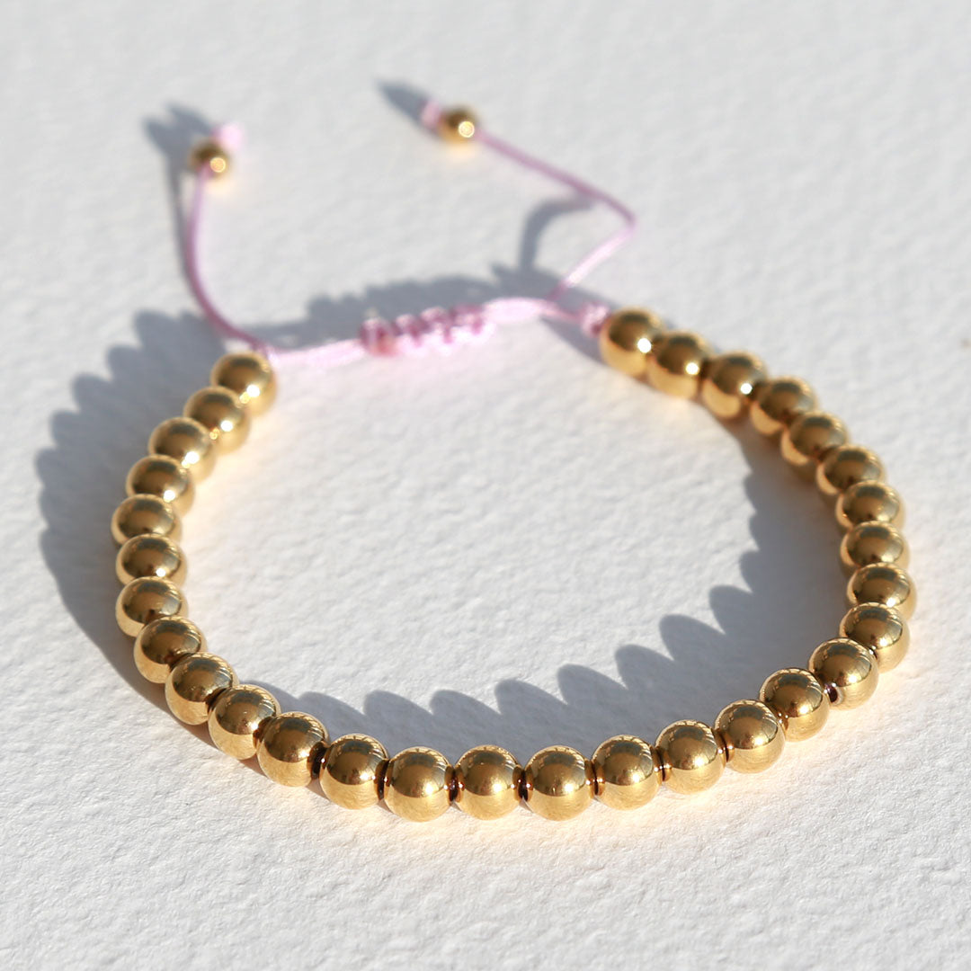 Armband gouden kraal roze