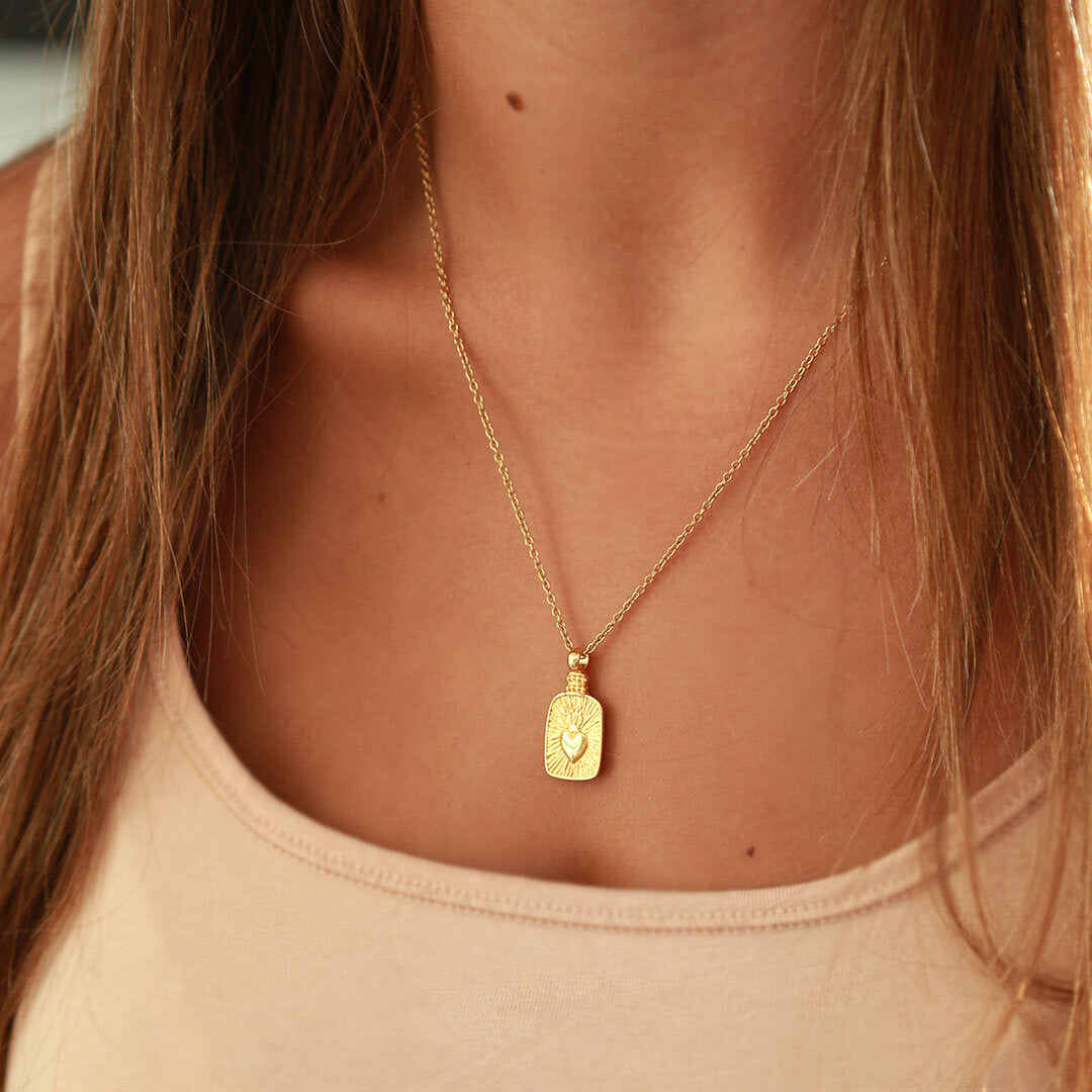 Collar de oro con corazón en llamas
